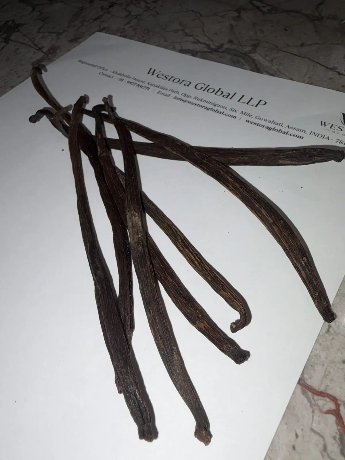 Bundle of dark, oily cured Vanilla planifolia pods from a Westora Global sample